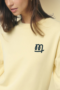 Exprimez votre style ou habillez vos équipes avec des pulls et hoodies personnalisés Une femme porte un pull jaune personnalisé sur le coeur
